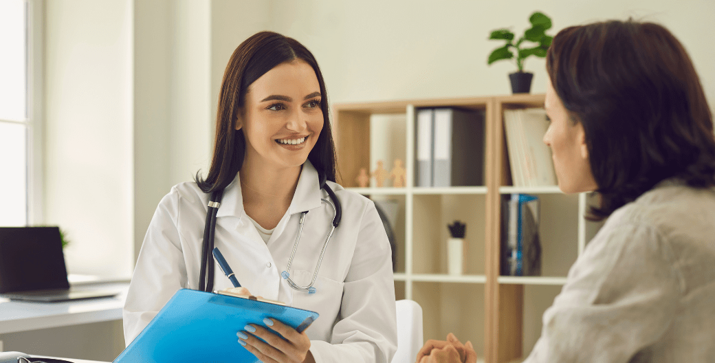 dos mujeres hablando y sonriendo en un consultorio médico