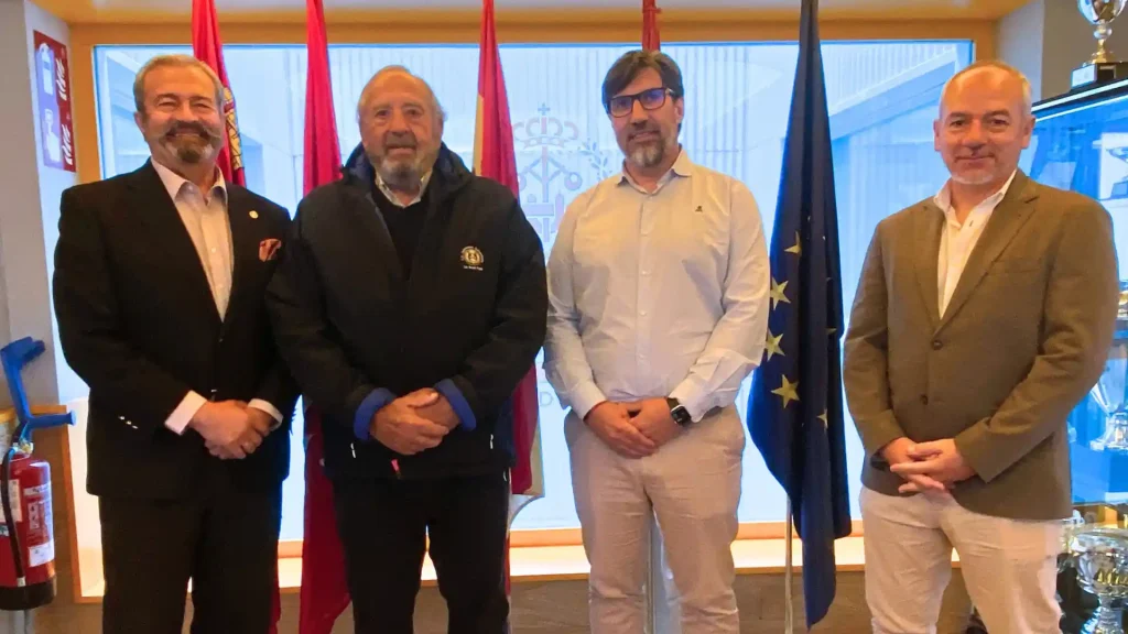 Foto grupal de cuatro hombres posando juntos en la firma del patrocinio del COIIM al club Ingenieros Industriales Las Rozas Rugby.